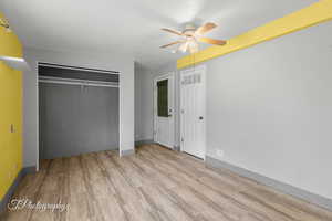 Unfurnished bedroom featuring wood finished floors and two closets