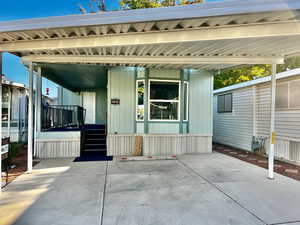 Entrance to property featuring a porch and a patio area