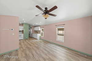 Unfurnished living room featuring ceiling fan, vaulted ceiling, light wood finished floors, and recessed lighting