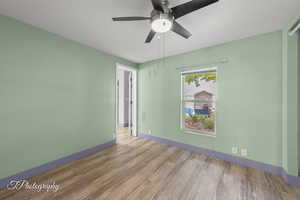 Empty room with wood finished floors and ceiling fan
