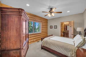 Bedroom with rustic walls, carpet, recessed lighting, and a ceiling fan