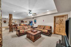 Living room with light carpet, ceiling fan, a textured ceiling, and recessed lighting