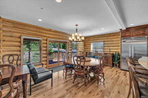 Dining area with recessed lighting, a chandelier, light wood-type flooring, and rustic walls