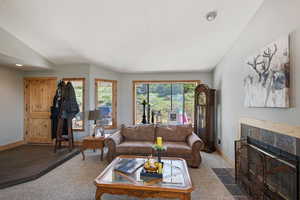 Living area featuring carpet flooring, a tiled fireplace, and recessed lighting