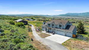 Aerial view of property and surrounding area with a mountain backdrop