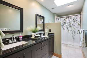 Full bathroom with double vanity, shower / bathtub combination with curtain, and tile patterned flooring