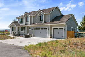 View of front facade featuring concrete driveway, a garage, and a chimney