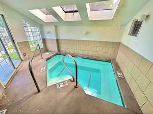 View of swimming pool featuring a skylight and a pool