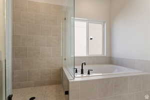 Full bathroom with a bath and a stall shower