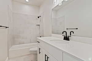 Bathroom with vanity, shower / bath combination, and recessed lighting