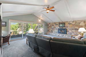 Living room featuring carpet floors, a ceiling fan, and a fireplace