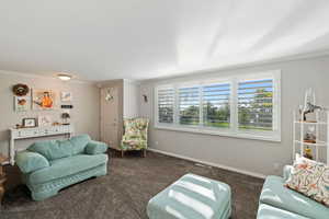 Large living room with big windows and plantation shutters.