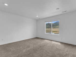 Carpeted spare room with recessed lighting and a mountain view
