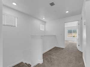Corridor featuring an upstairs landing, carpet, and recessed lighting