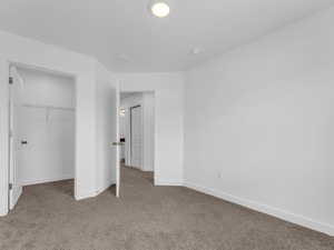 Unfurnished bedroom with carpet floors and baseboards