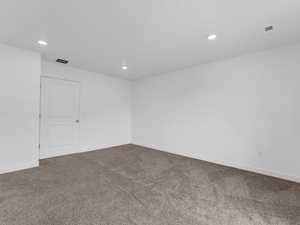 Carpeted empty room with recessed lighting and baseboards
