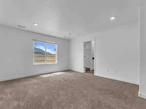 Carpeted spare room featuring recessed lighting and a textured ceiling
