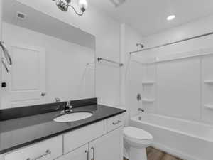 Bathroom featuring wood finished floors, vanity, and bathtub / shower combination