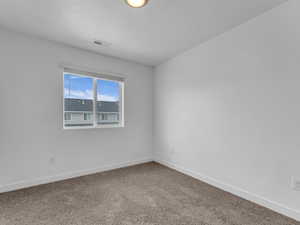 Carpeted spare room with baseboards