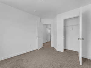 Unfurnished bedroom with carpet and a closet