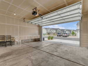 Garage featuring a garage door opener and a residential view