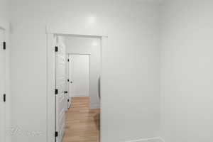 Hallway featuring light wood finished floors and baseboards