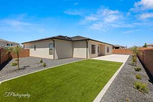 Back of property with a fenced backyard, a patio area, and stucco siding