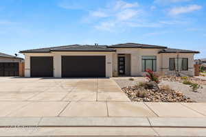 Prairie-style house with an attached garage, concrete driveway, a tile roof, and stucco siding