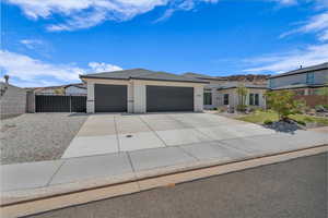 View of front of house featuring an attached garage, driveway, stucco siding, and a tiled roof