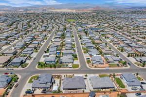 Aerial overview of property's location with nearby suburban area and a mountainous background