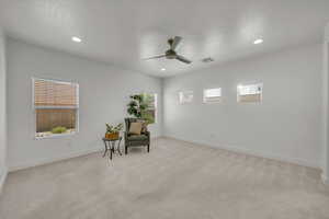 Sitting room featuring plenty of natural light, ceiling fan, light colored carpet, and recessed lighting