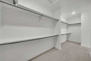 Spacious closet with light colored carpet