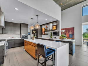 Kitchen with a breakfast bar area, open shelves, hanging light fixtures, recessed lighting, and a kitchen island