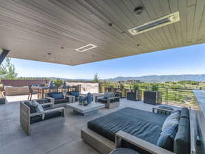 View of patio featuring an outdoor living space with a fire pit and a mountain view