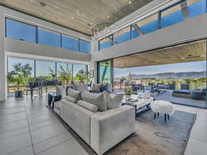 Living room with a mountain view, recessed lighting, a high ceiling, wood ceiling, and tile patterned floors