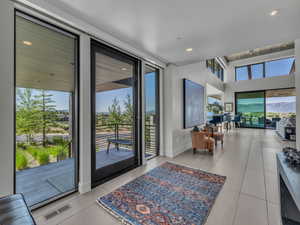 Doorway featuring recessed lighting, tile patterned flooring, and a high ceiling