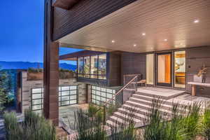 View of exterior entry featuring a mountain view and a patio