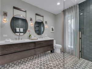Full bathroom with a shower stall, double vanity, recessed lighting, and light tile patterned flooring