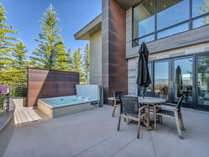 View of patio / terrace featuring an outdoor hot tub and outdoor dining area