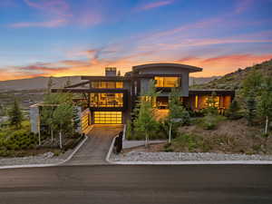 Modern home with driveway, a mountain view, an attached garage, and a chimney