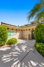 View of front facade with stucco siding, a tile roof, and a patio area