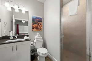 Bathroom featuring vanity, a stall shower, wood finished floors, and ceiling fan