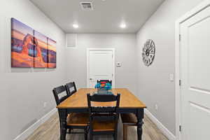 Dining room with light wood-type flooring and recessed lighting
