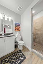 Bathroom featuring vanity, wood finished floors, a stall shower, a textured ceiling, and ceiling fan