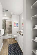 Bathroom with vanity, wood finished floors, shower / tub combo, and a textured ceiling