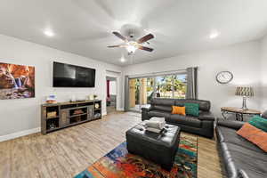 Living room featuring a ceiling fan, wood finished floors, and recessed lighting