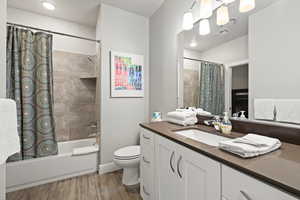 Full bath featuring vanity, shower / tub combo, and wood finished floors