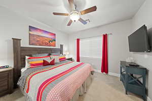 Carpeted bedroom with ceiling fan and baseboards