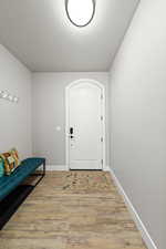 Foyer entrance featuring light wood-style flooring and a textured ceiling