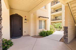 Doorway to property featuring stucco siding